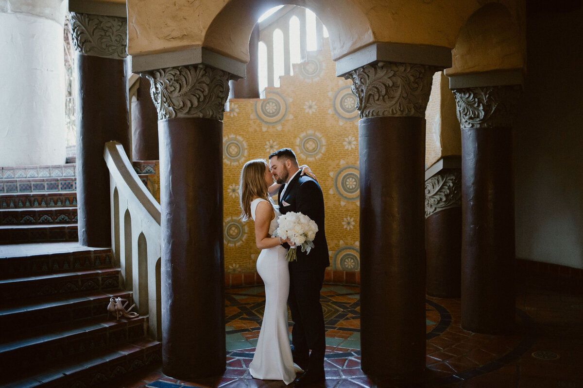 bride-and-groom-kissing-in-luxurious-foyer