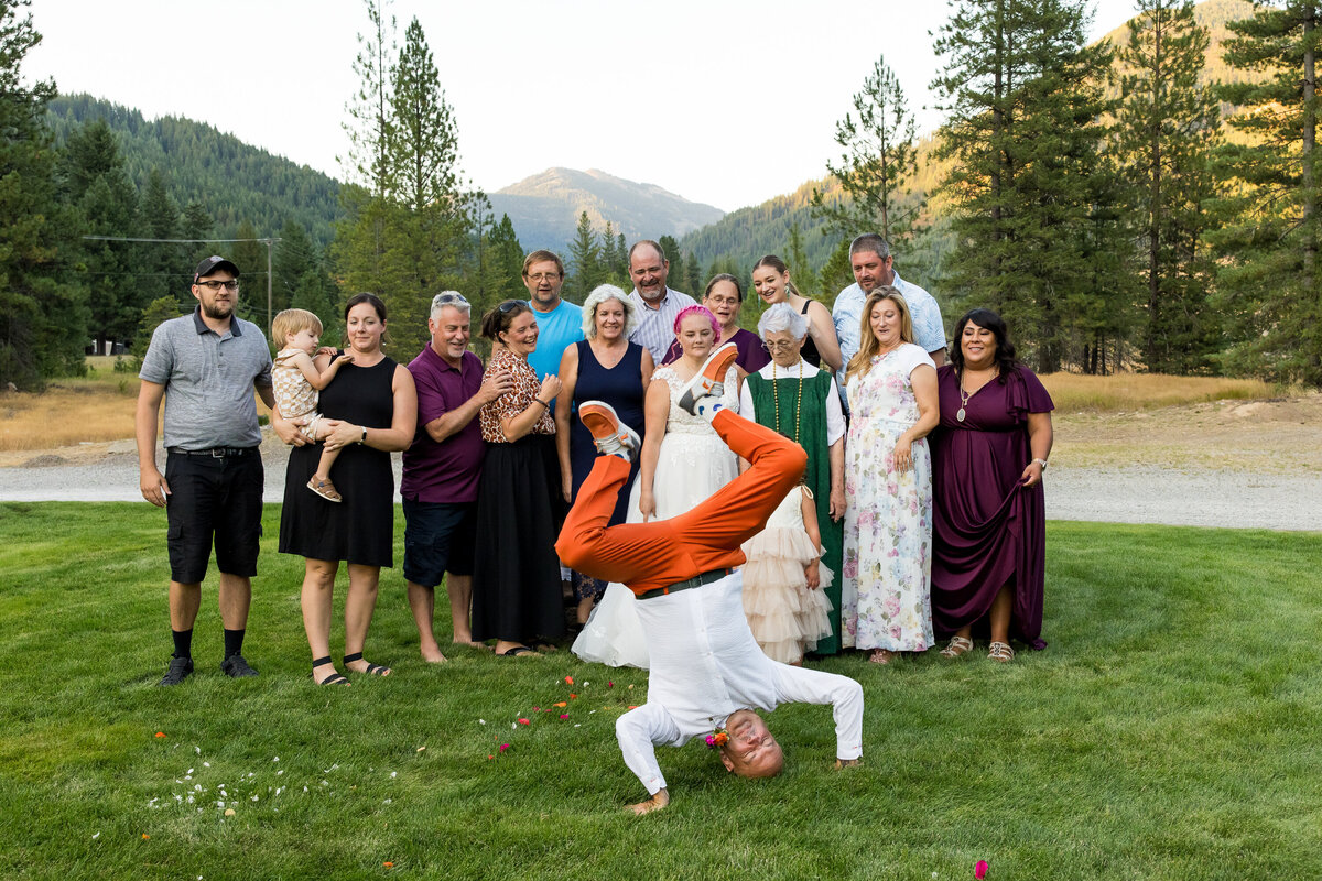 A groom makes a unique entrance into his family portrait following his Wallace, Idaho wedding ceremony.