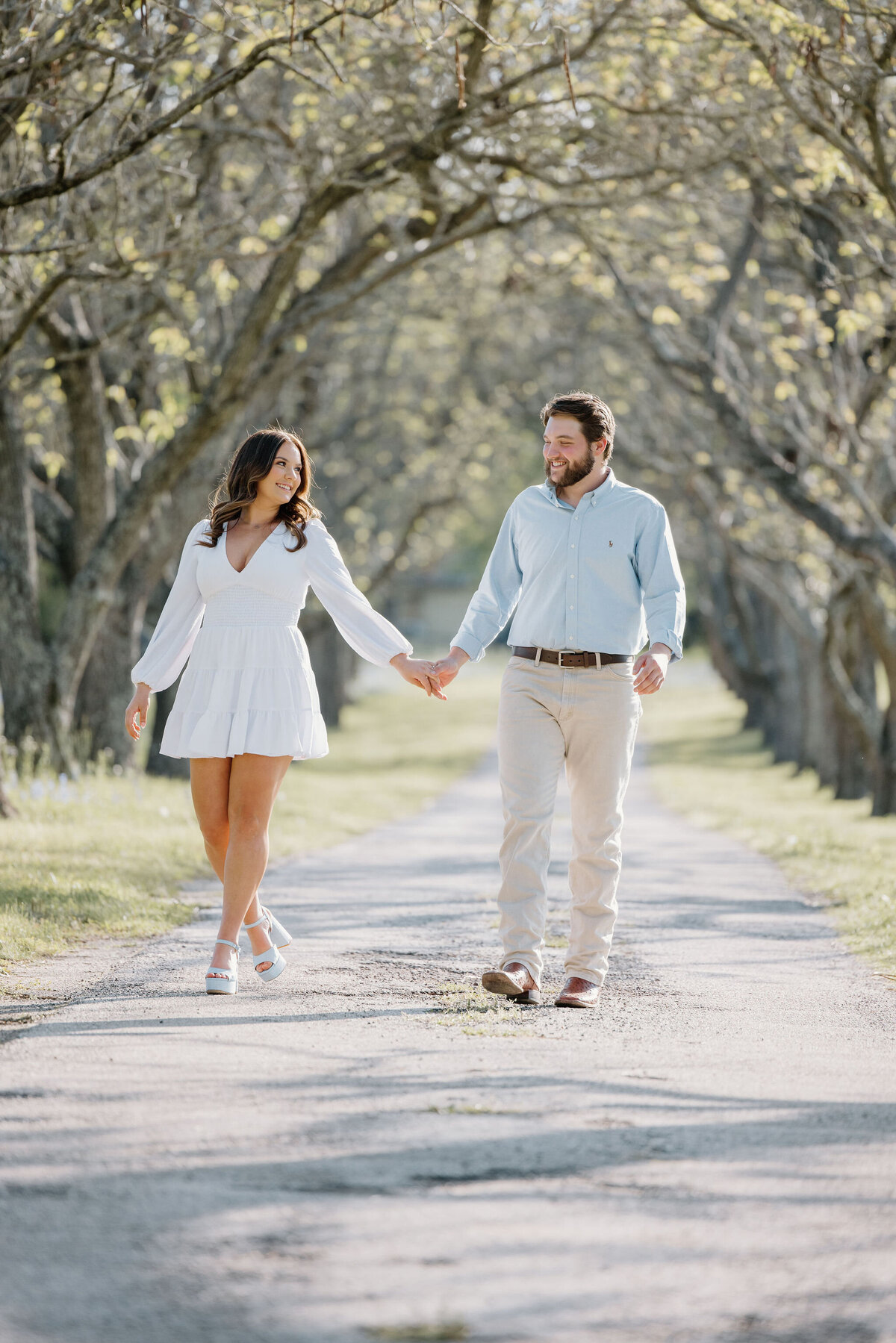 candid engagement photos of young Longview Texas couple walking and holding hands