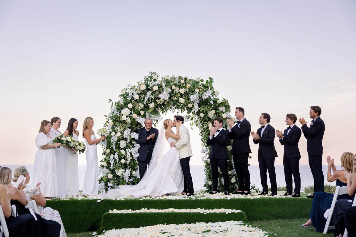 The bride and groom sharing their first kiss at the wedding alter.