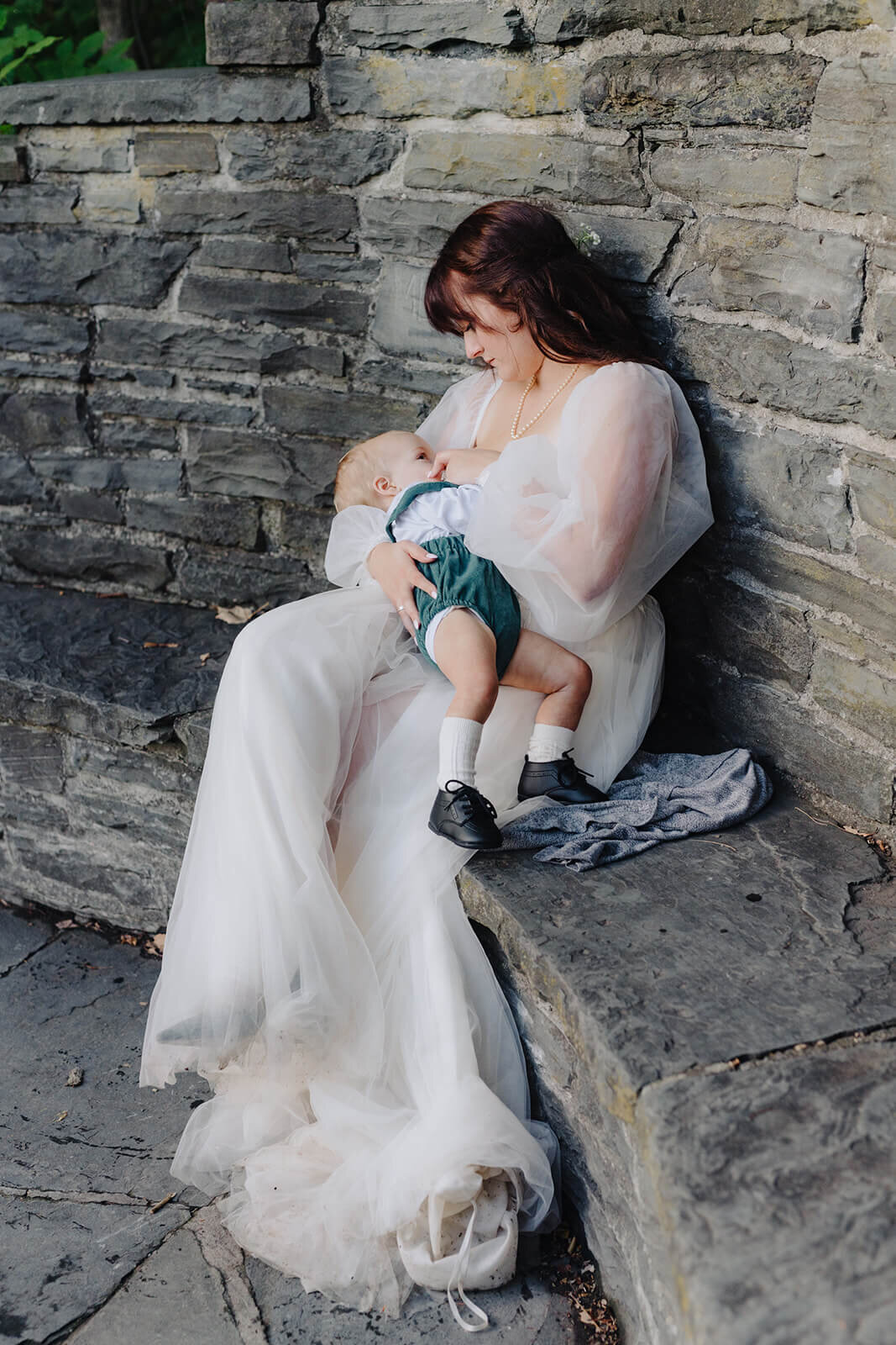 bride breastfeeding baby in her wedding dress