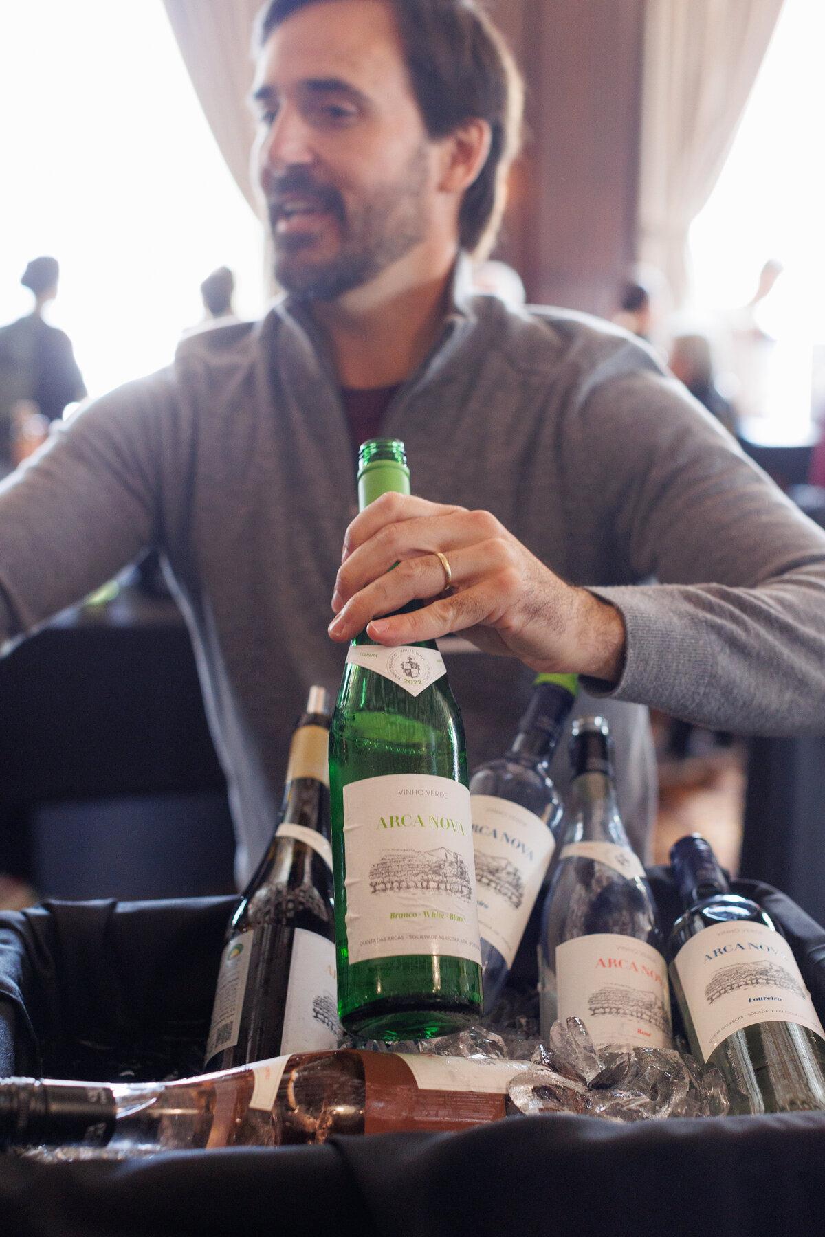 A man holding a green bottle of wine