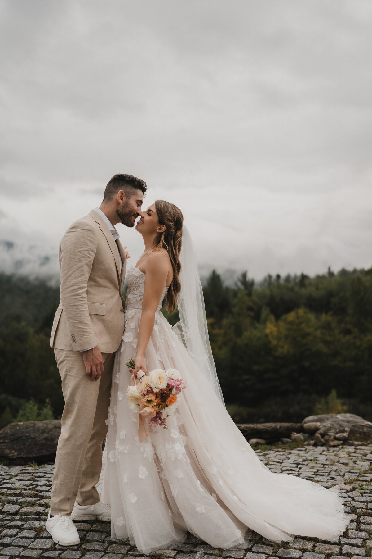 couple-mariage-chateau-st-agnes-baiser-romantique-montagne-robe-fleurs