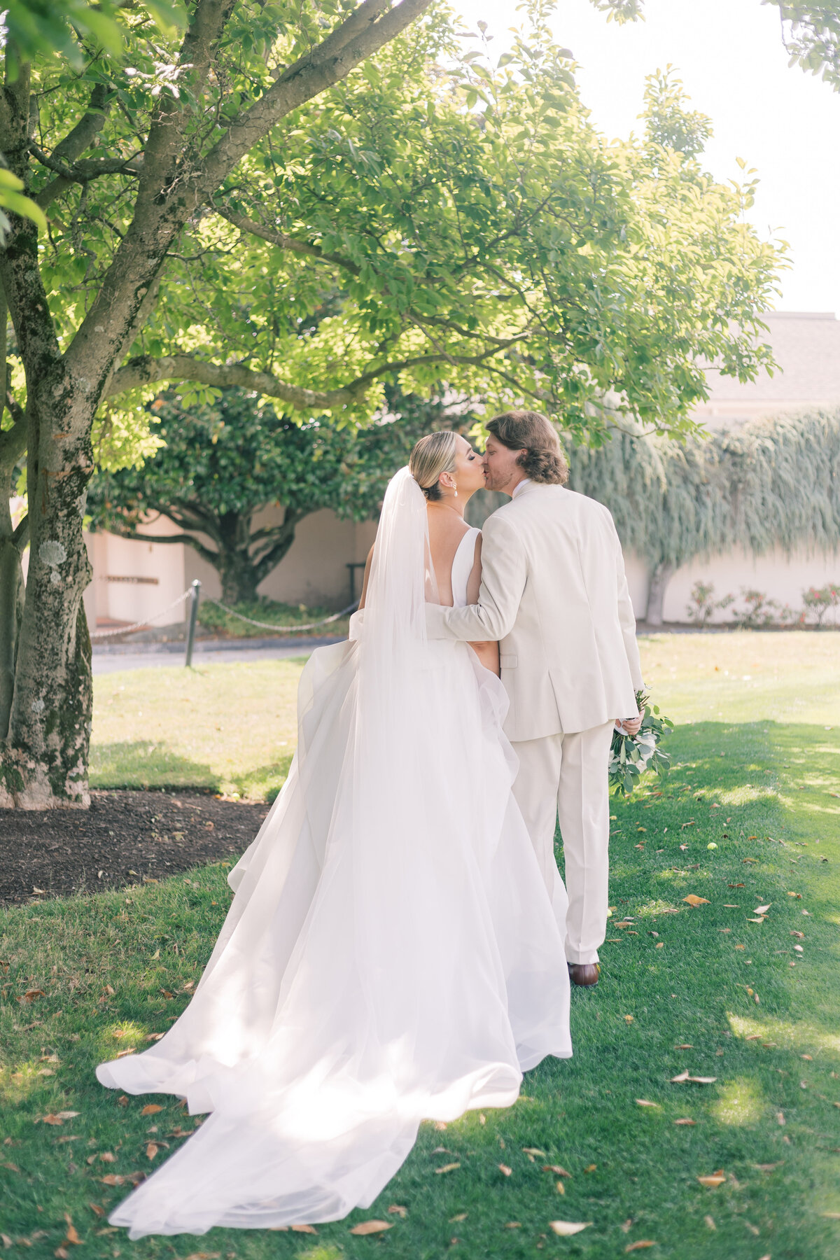 Couple holding hands and walking on a Maryland golf course during their wedding day, enjoying the moment together.