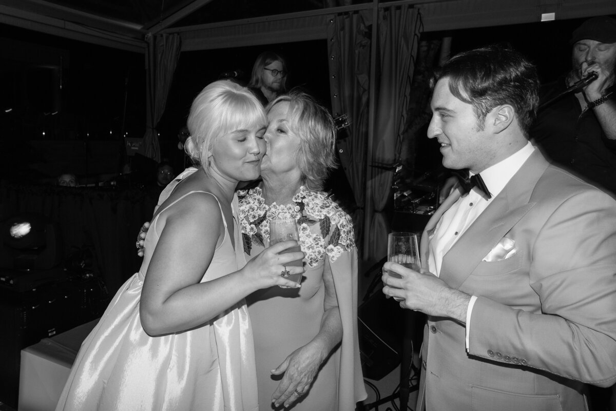Sister and mother of bride embracing at a wedding in black and white