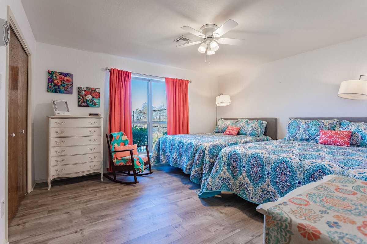 Bedroom with two queen beds and beautiful view of the lake in this 2-bedroom, 2-bathroom lakeside vacation rental home for 6 guests on Tradinghouse Lake with privacy access to a fishing dock and boat launch pad, ping pong table, gazebo, free wifi and free parking in Waco, TX.