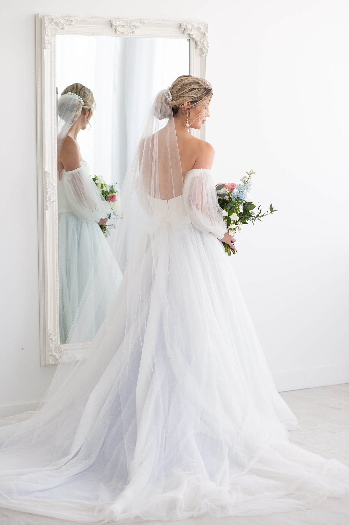 a full length photo showing the low back of an Ottawa bride's dress in a mirror reflection taken by Ottawa wedding photographer JEMMAN Photography