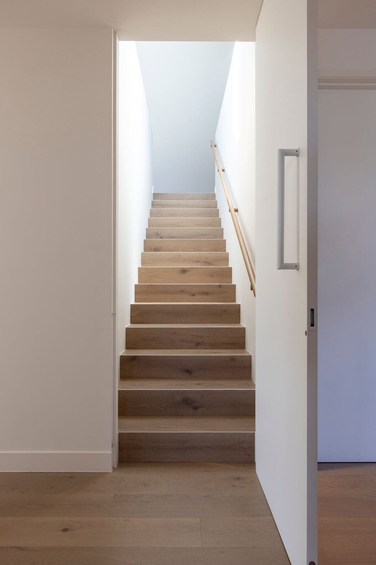 Opening of the hidden white door leading to stairs