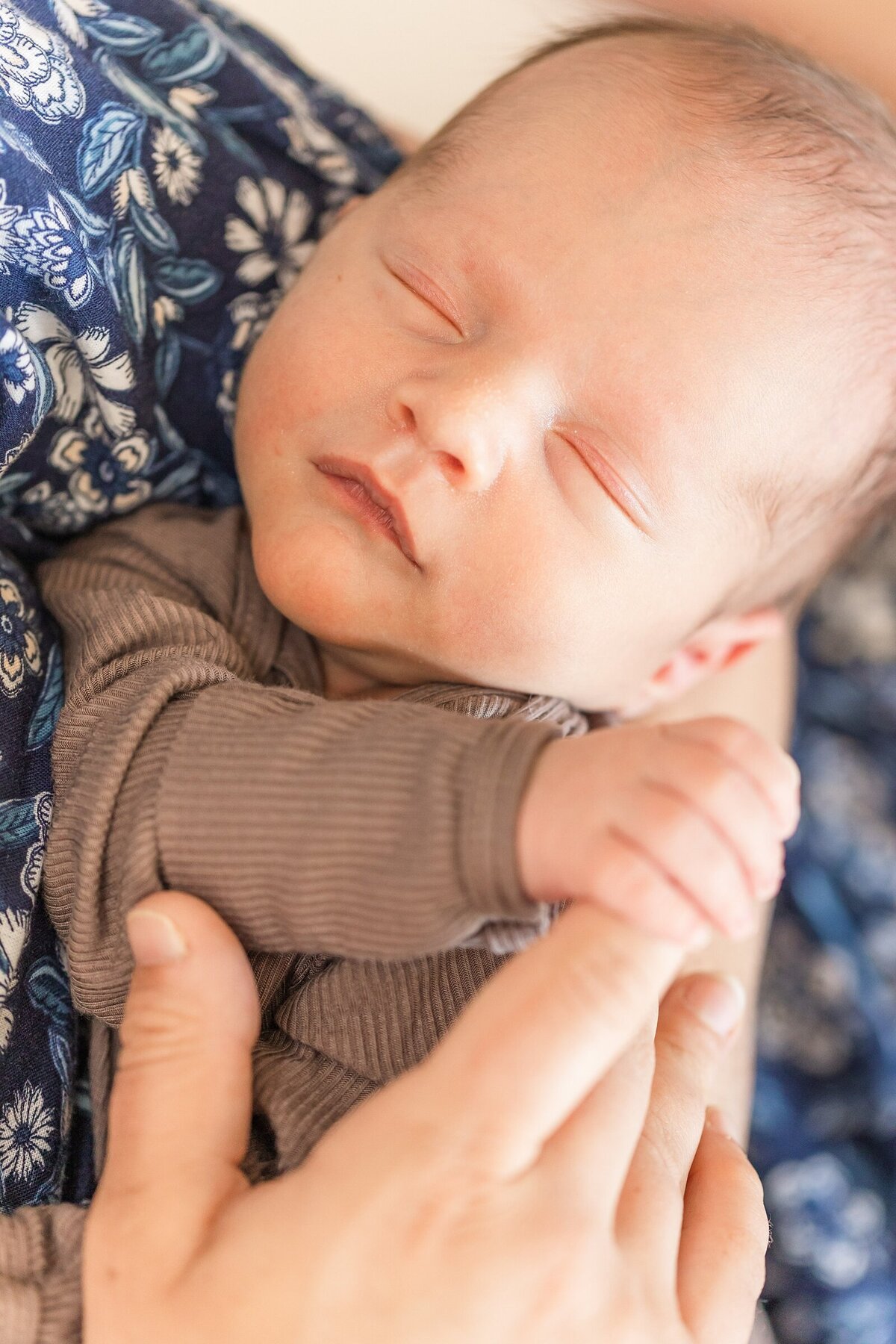 Baby boy holding his mama's finger in a lifestyle newborn session