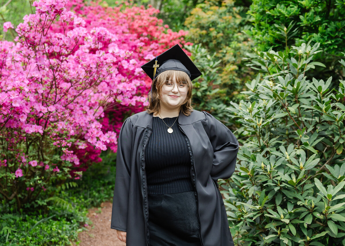 Woman wearing graduation cap and gown in a beautiful park in NJ