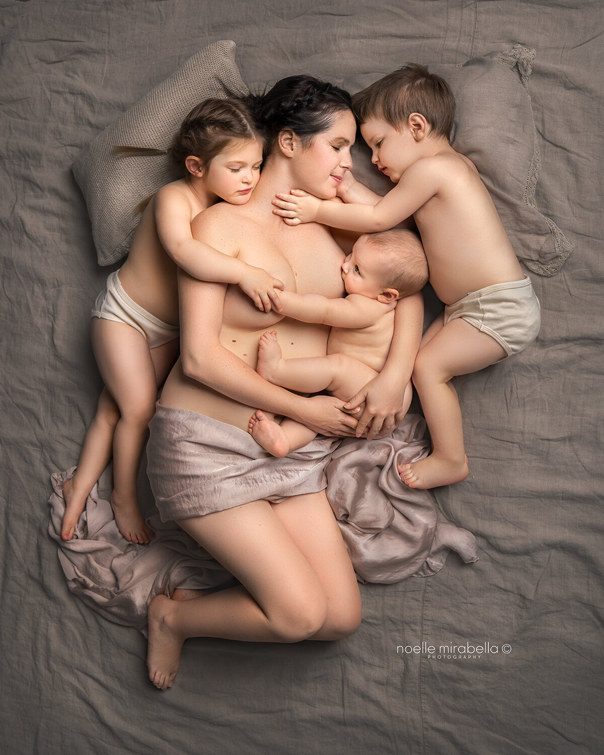 Mother and Children Snuggling in bed.