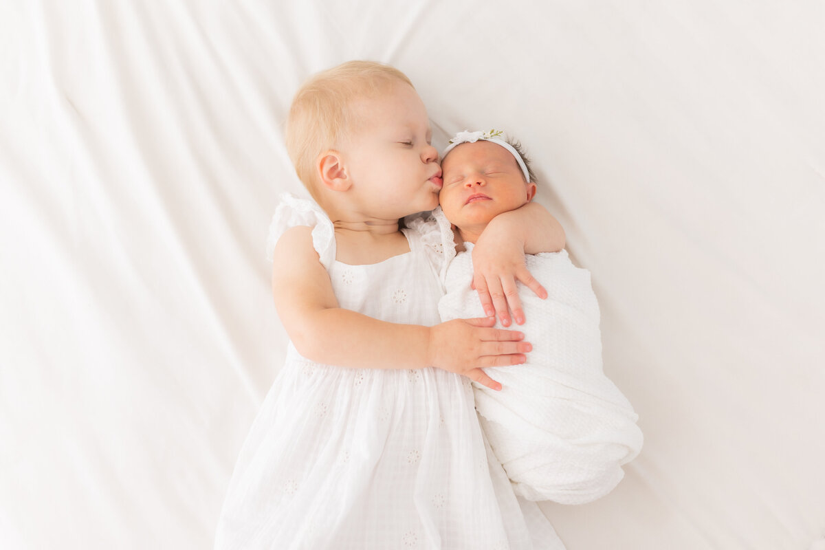 newborn-sisters-kiss