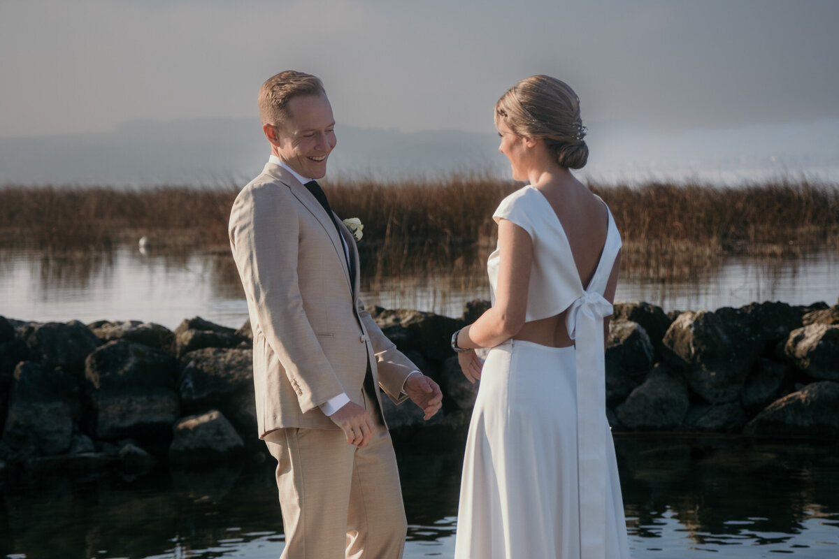First look of the wedding couple at a lake.