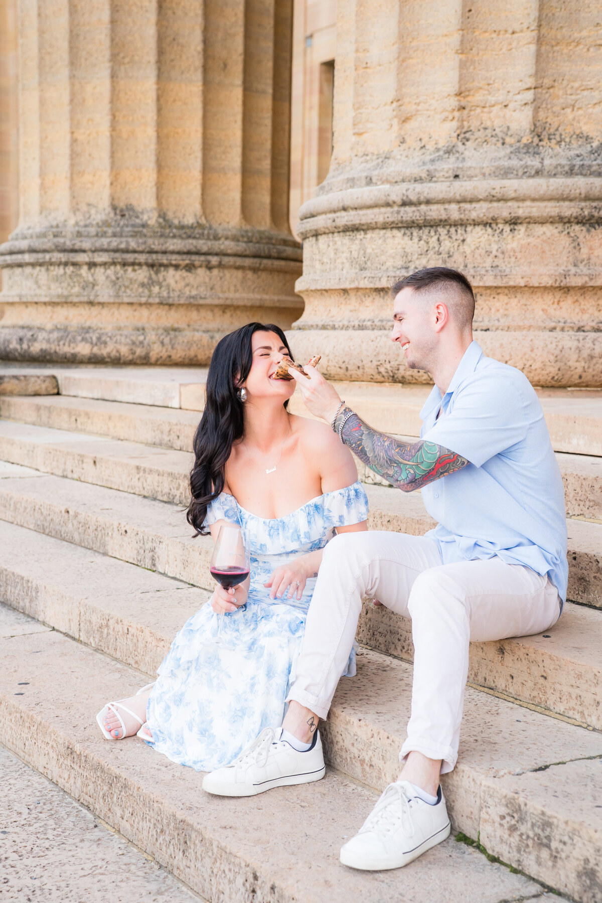 bride and groom enjoying pizza on the steps of the philadelphia art museum 