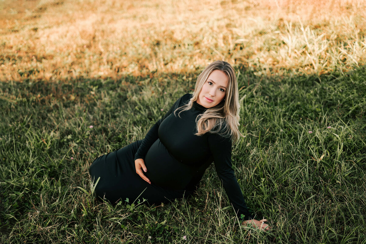 pregnant mom in black dress holding baby bump