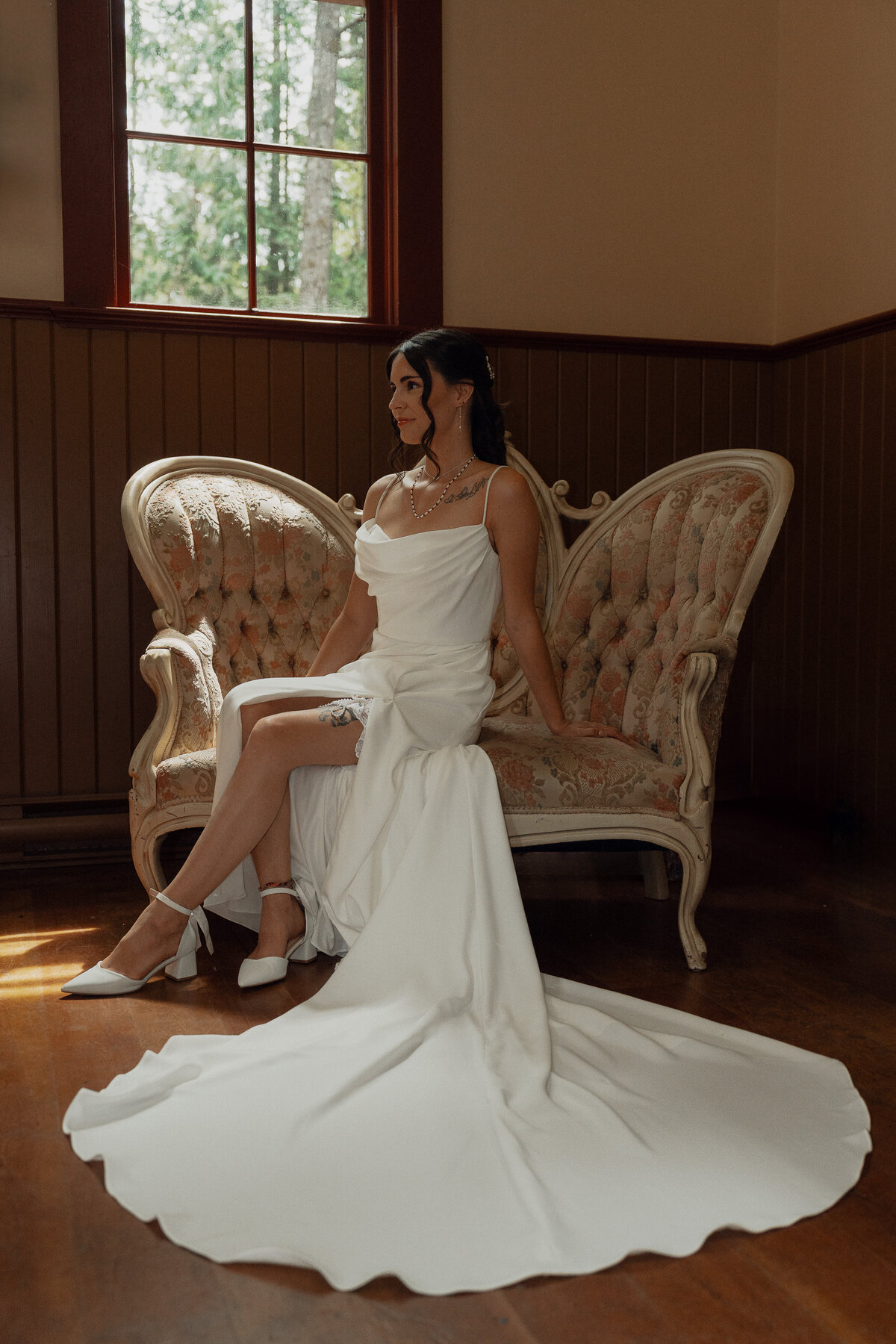 Bride sitting on a vintage settee during her getting ready wedding portraits at Caleb Pike Heritage Park in Victoria by Latitude 49 Photography