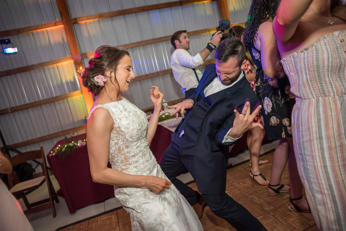Bride and Groom playing air guitar and dancing.