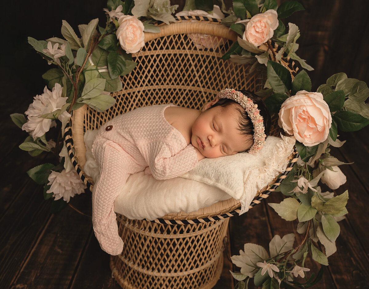 Sleeping Toronto  newborn photos of girl infant sleeping in a peacock chair with rose vine decor.
