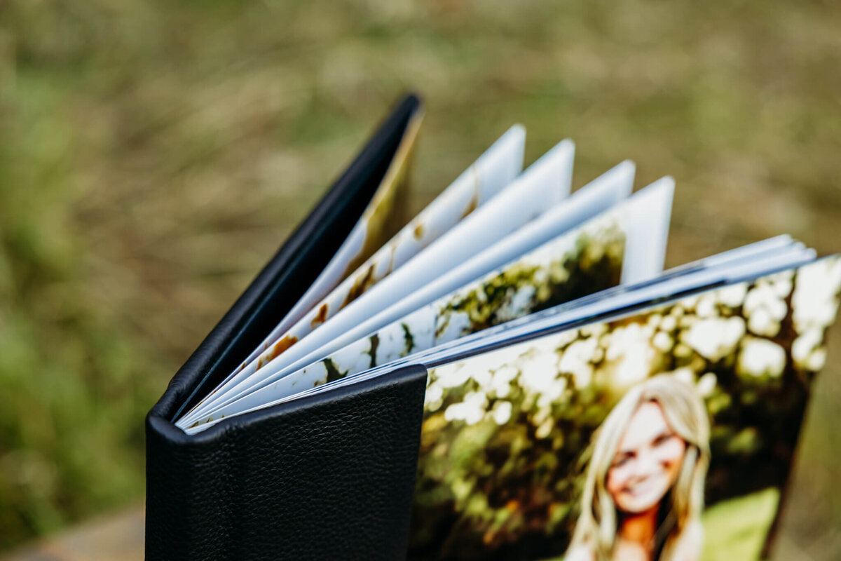 photo of the top of a black album with a photo of a teen girl on the cover to show the thickness of the pages and binding