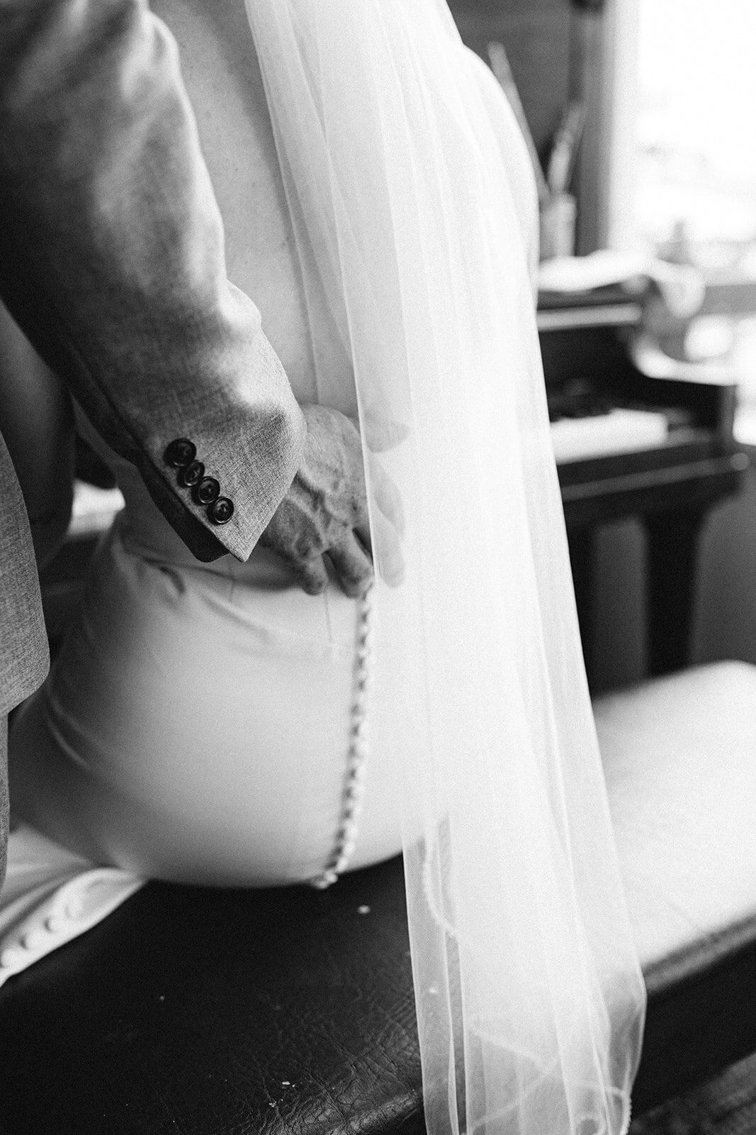 Bride sitting with grooms hand on her back, captured by Bryttanni,  luxury and artistic wedding photographer in Edmonton, Alberta. Featured on the Bronte Bride Vendor Guide.