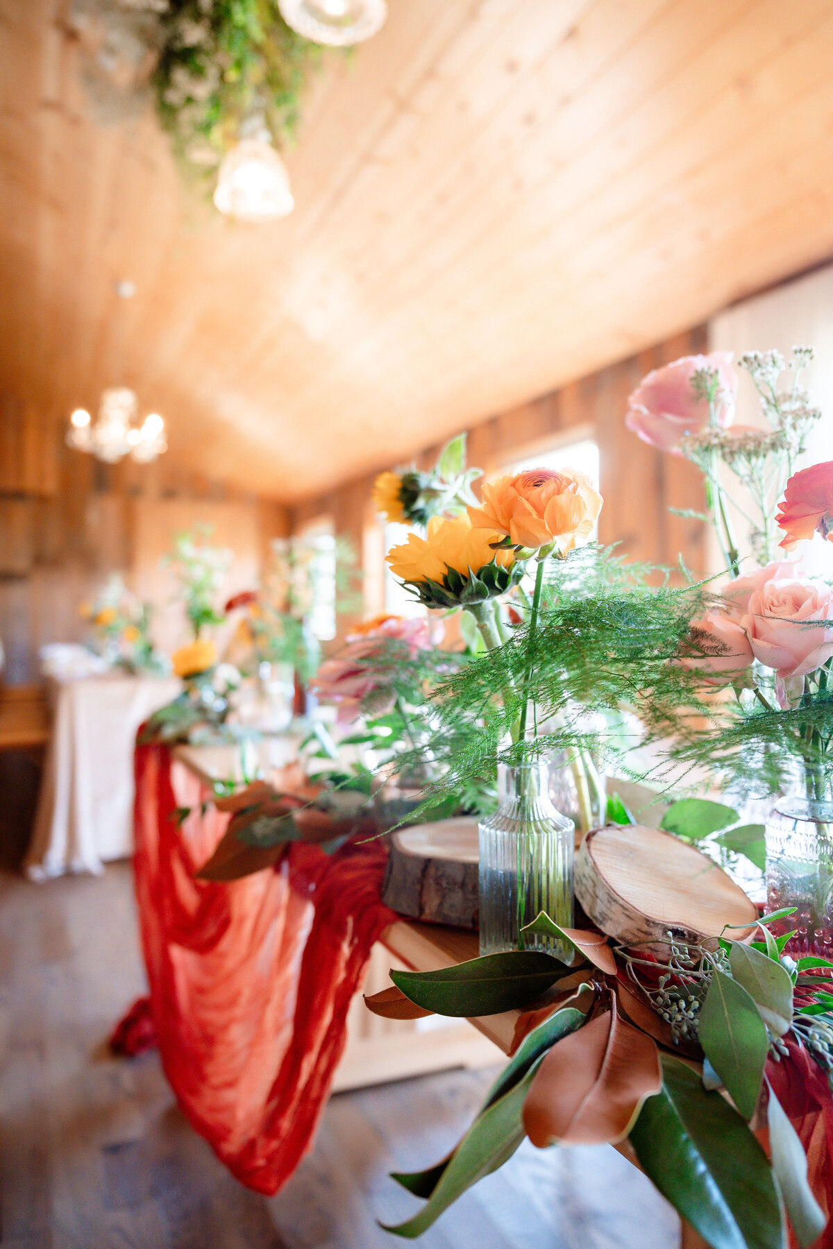barn wedding decor in autumn season with oranges pinks and sunflowers
