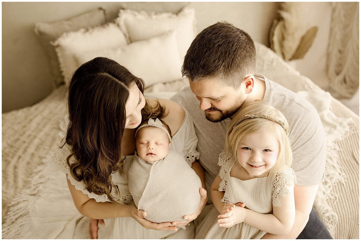 Parents from Cleveland holding newborn baby for a family photo