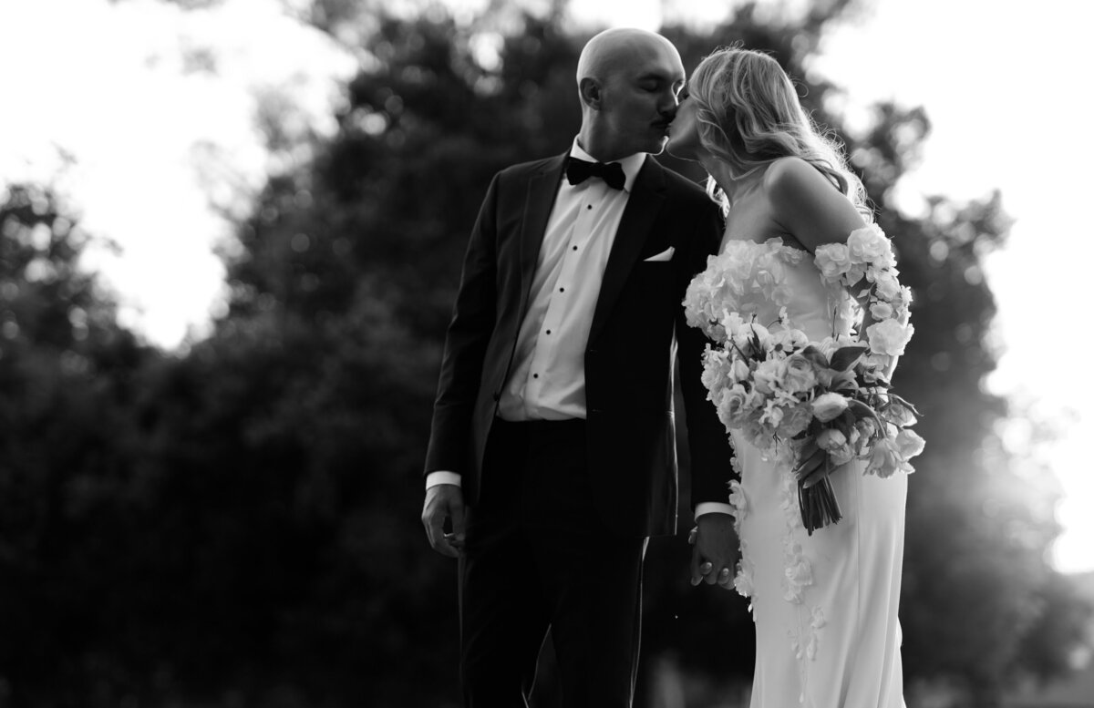 bride and groom kissing in the grounds of Muckenthaler Mansion