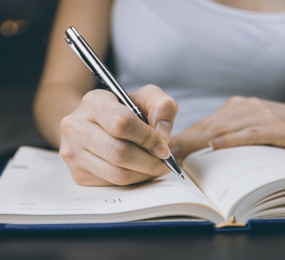 hands of woman writing in notebook