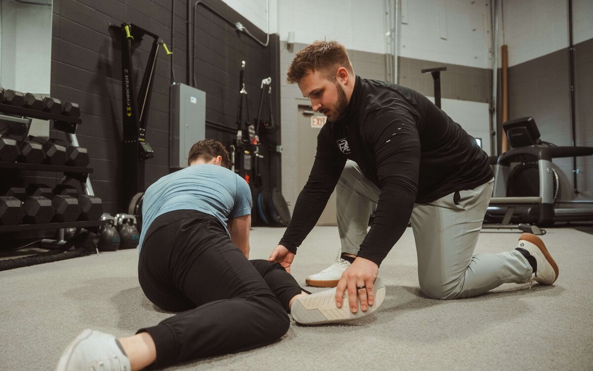 Rehab specialist assessing patient’s movement to create a customized treatment plan