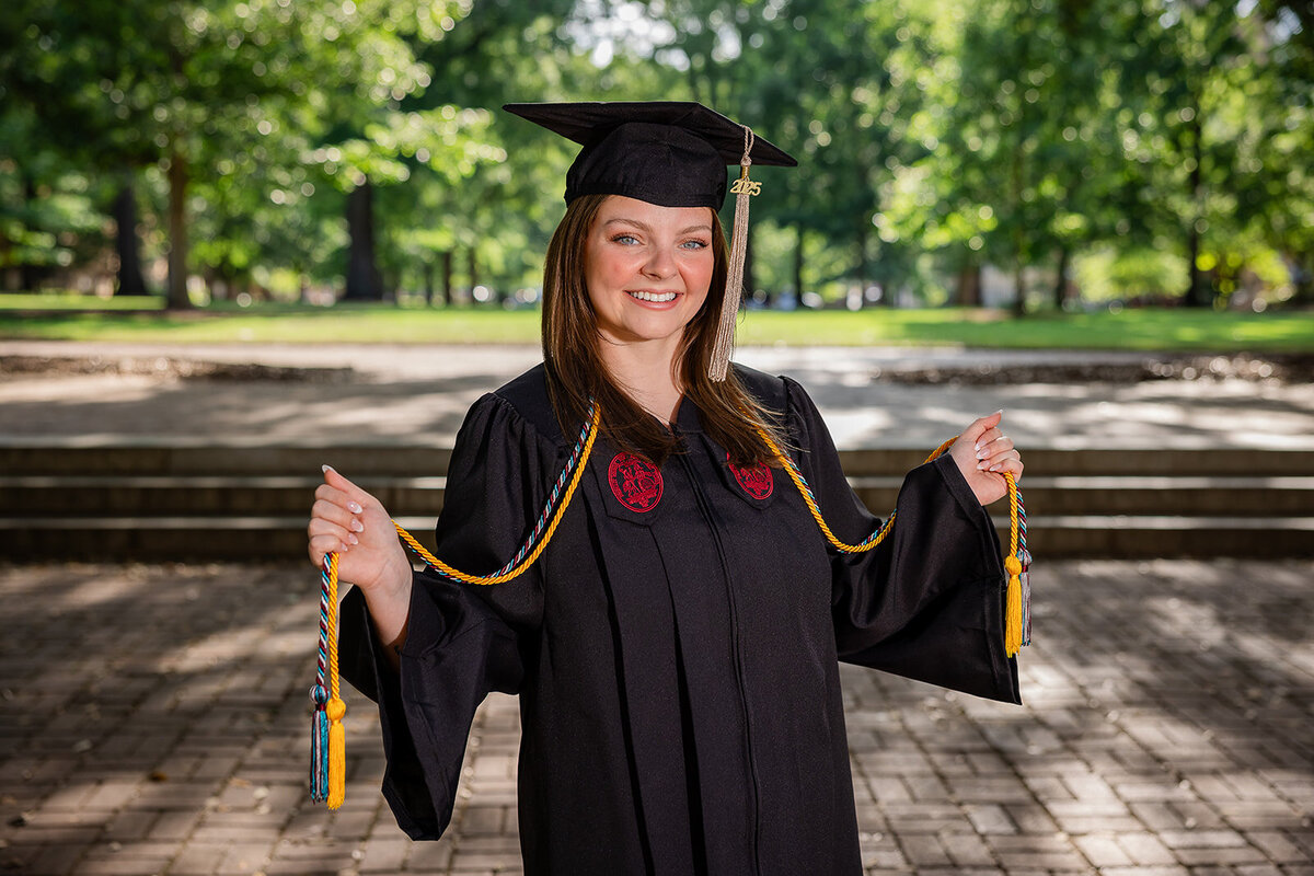 A girl posing for her senior portraits on the University of South Carolina's campus