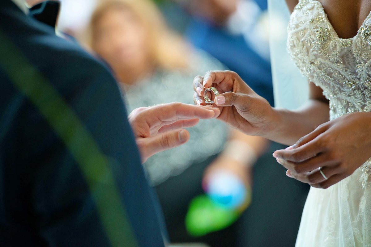 Bride placing the ring on the groom's finger at Fox Hollow