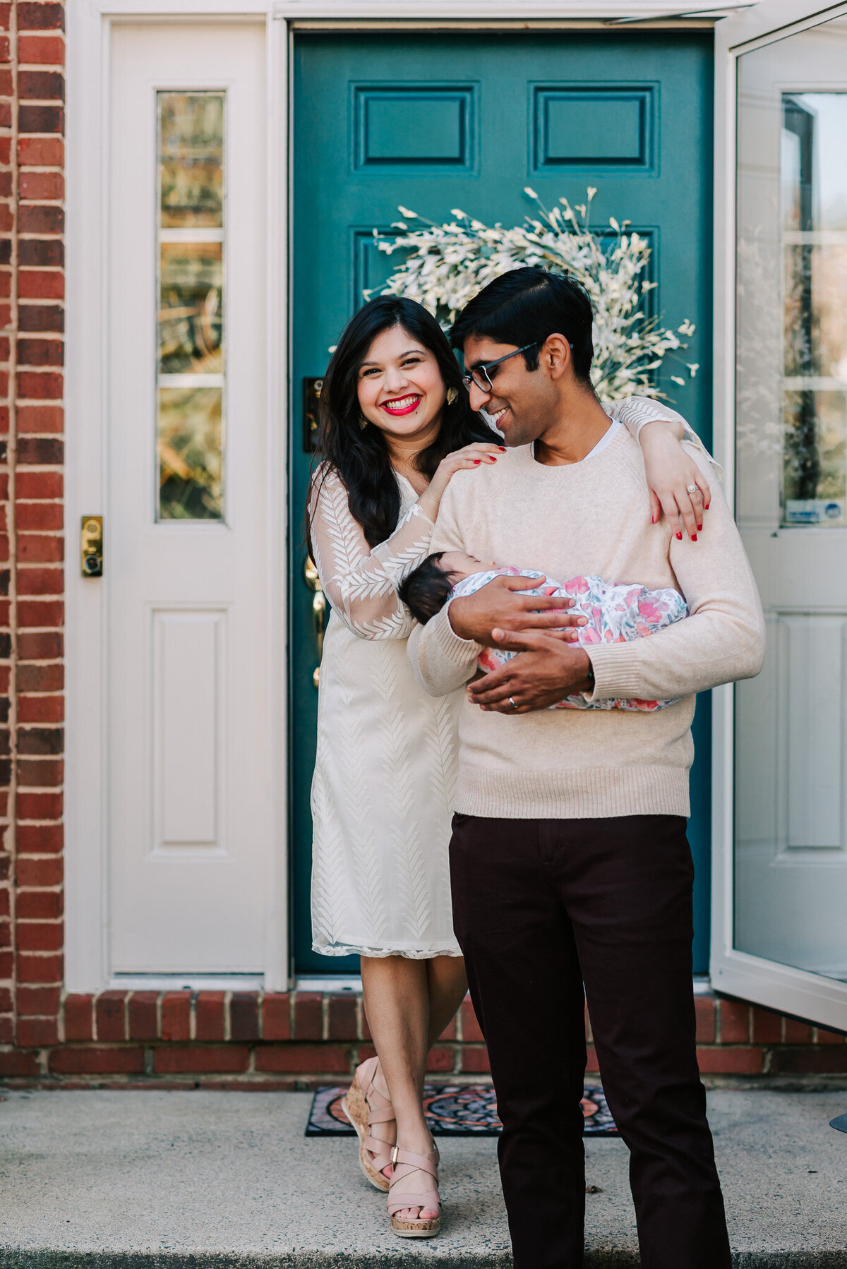 candid moment of indian family on their front porch during their newborn photography by Denise Van