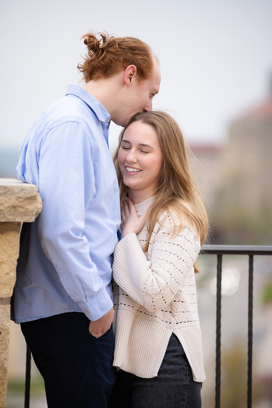 man kisses top of woman's head after engagement