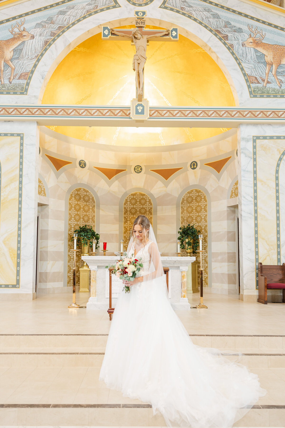 bride holding a flower bouquet while standing in a church