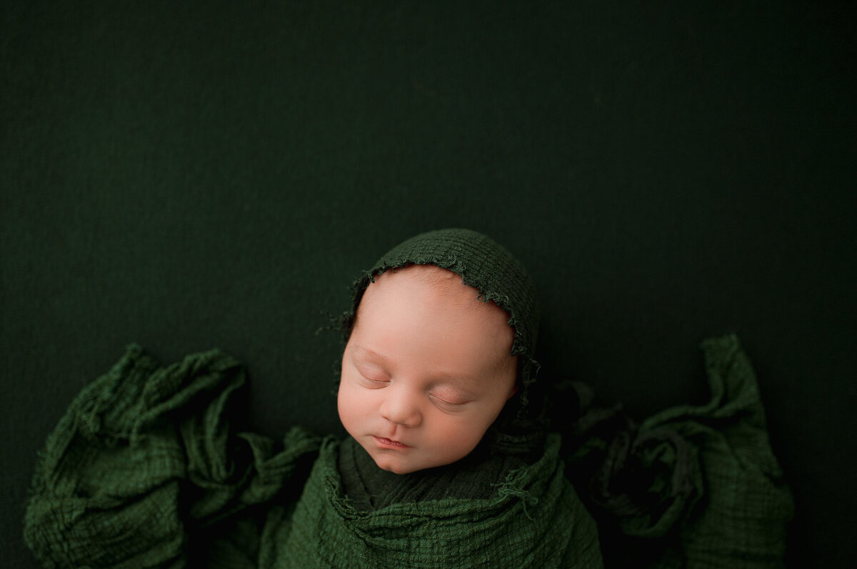 Newborn in swaddle with matching hat