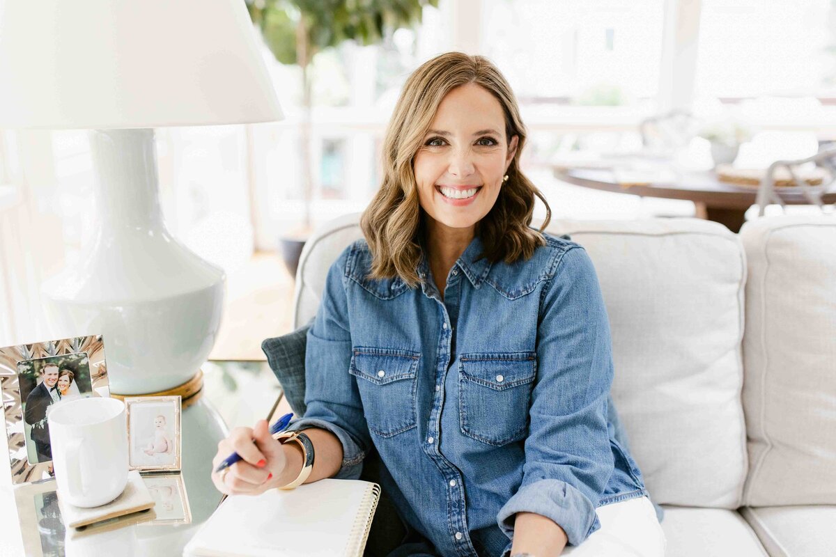 Jennifer sitting on her couch with her journal ready and pen in hand | Health and Mindset Coach for Women and Mom