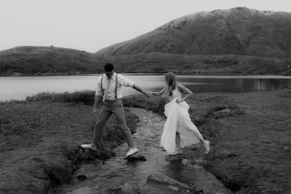 black and white image bride and groom holding hands