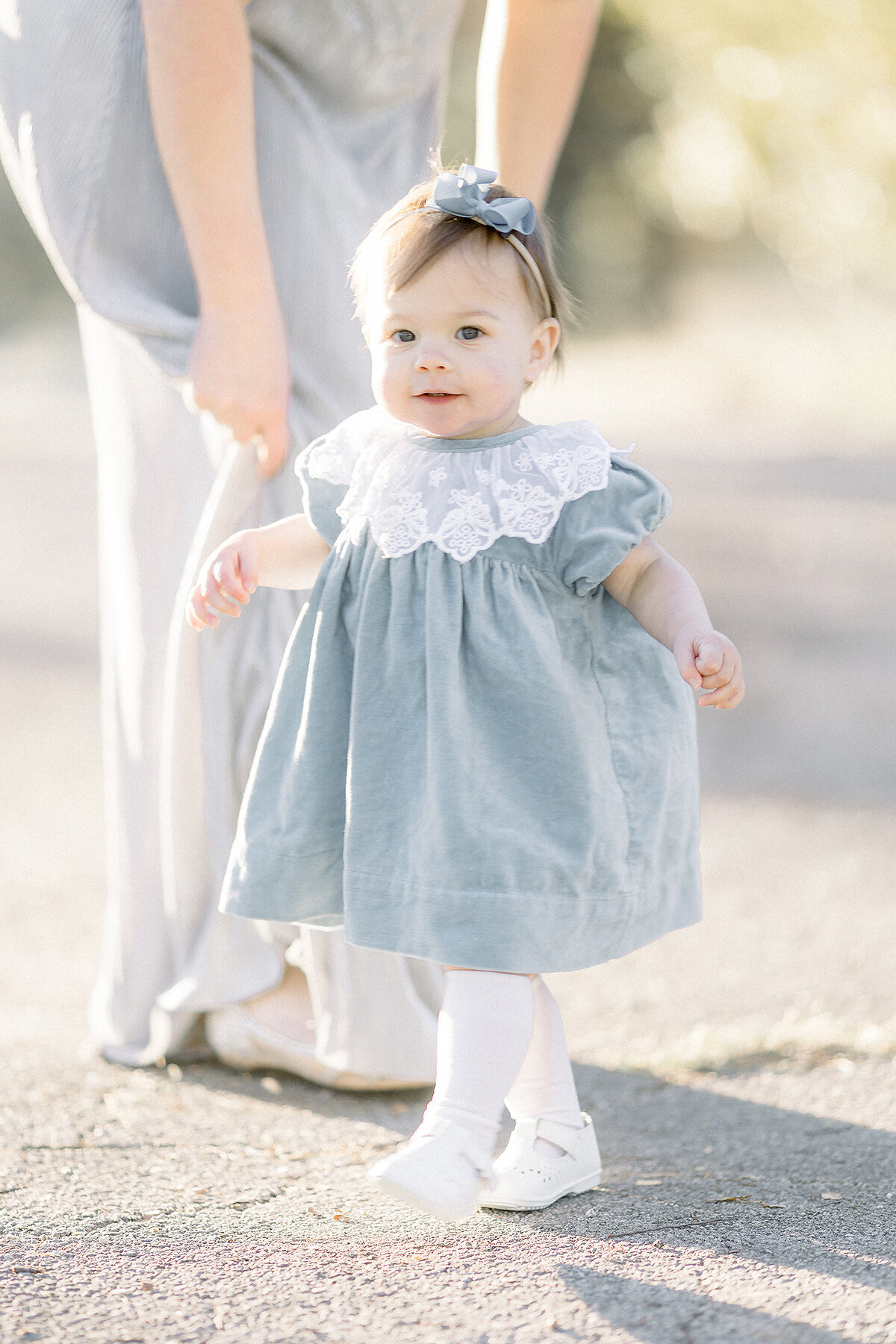 Photo of a little girl in a Fort Worth park wearing a light blue velvet dress for her family session.