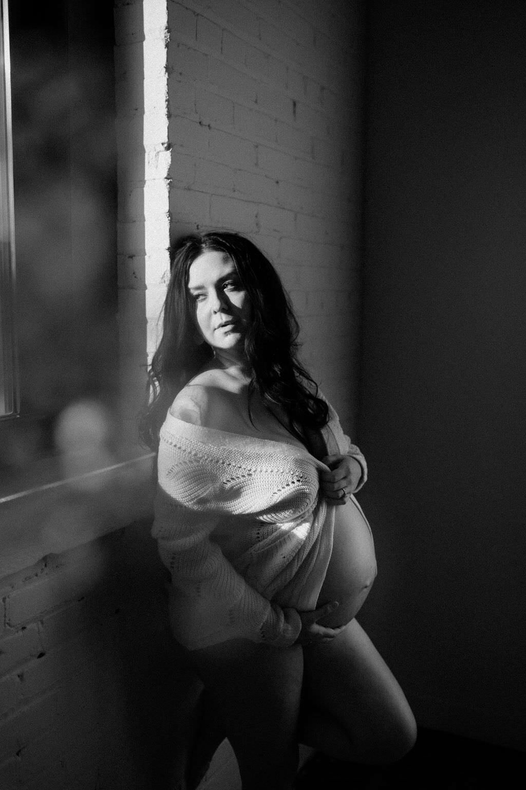 black and white image pregnant woman holding belly