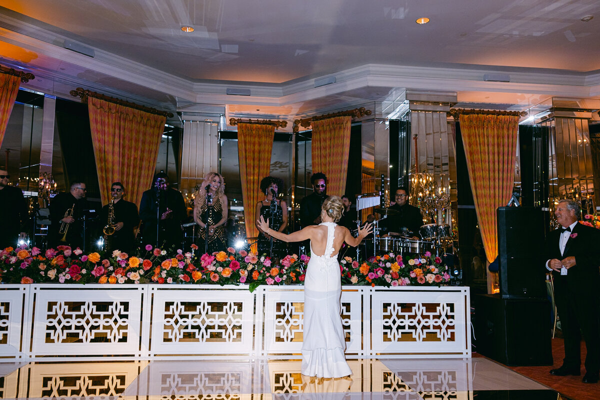 A wedding day photo of the bride dancing in front of the band during her reception