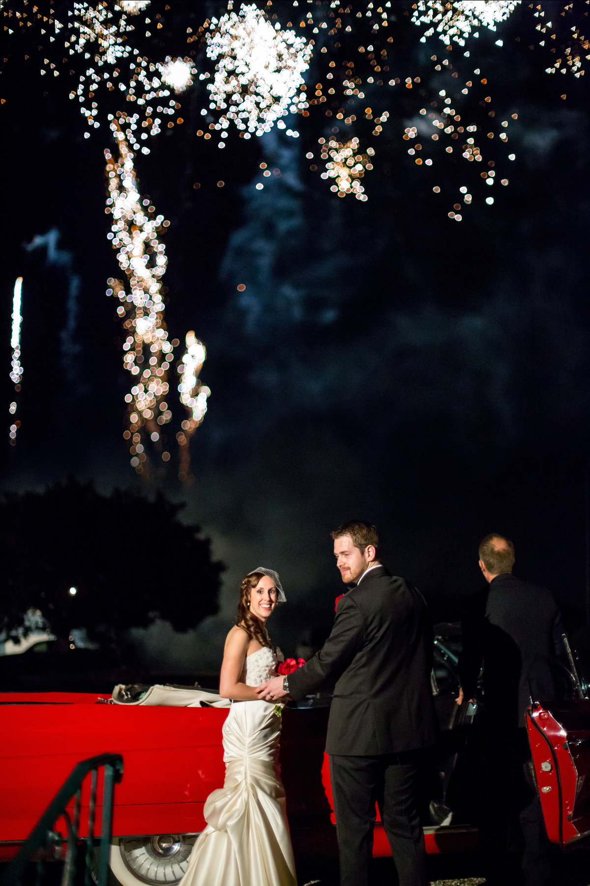 bride and groom exit wedding reception venue in classic car and fireworks at Oak Valley Vineyards Garden Ridge Texas