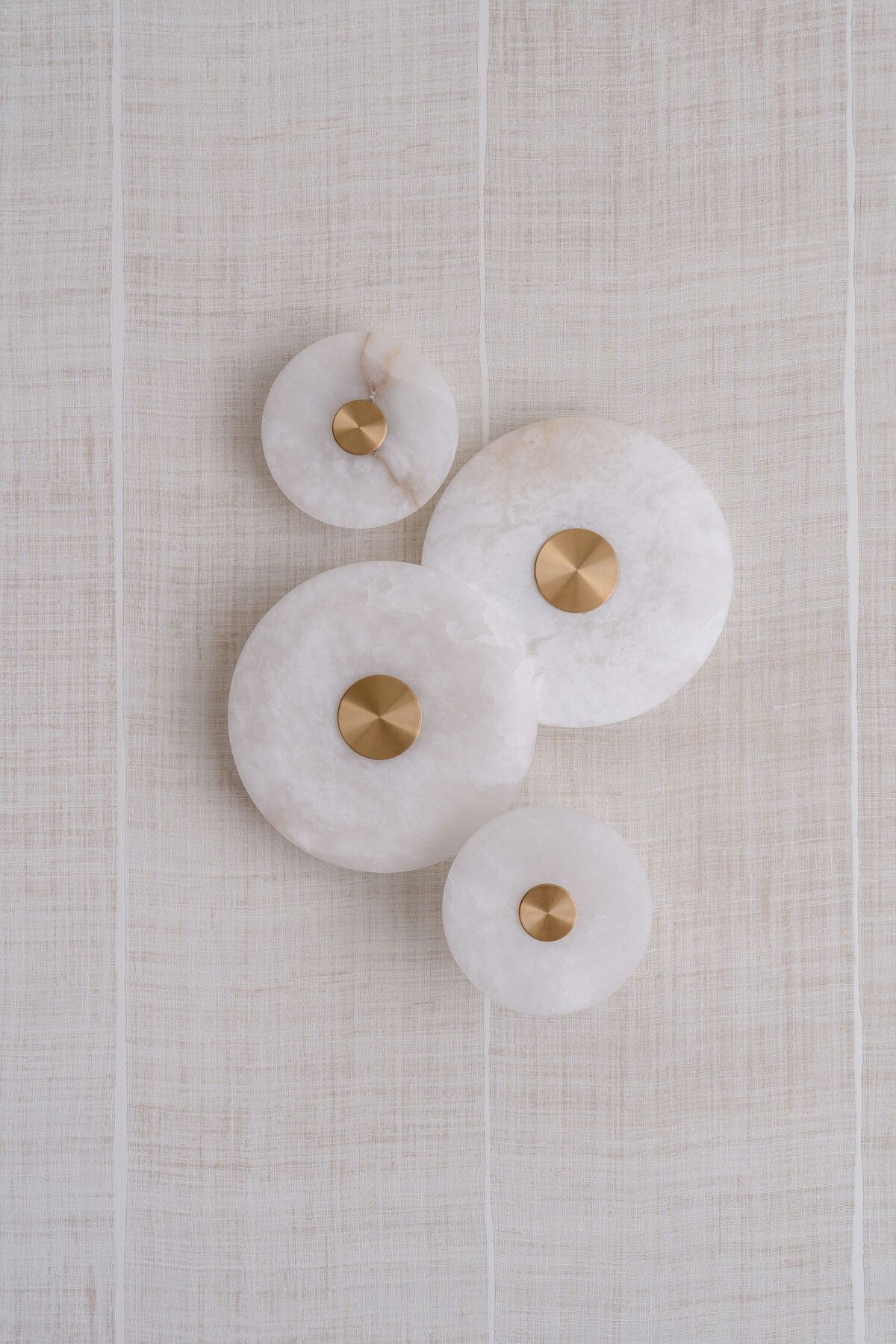 A contemporary wall art piece featuring marble circles of various sizes with gold centers.