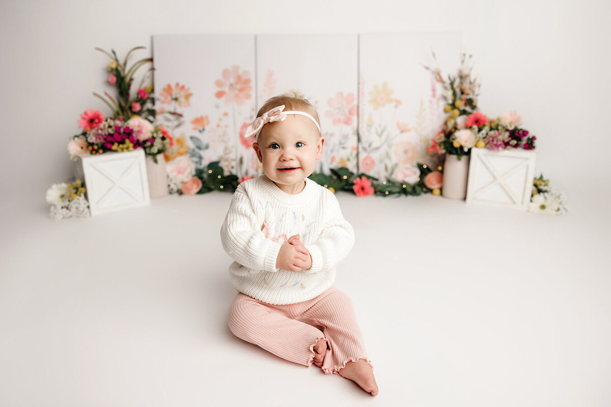 Cute one year old girl with flowers at her Fort Collins cake smash session