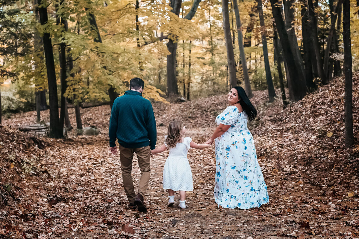 Family walking down trail in the woods and beautiful maxi dress at Stark Park in Manchester NH by Lisa Smith Photography