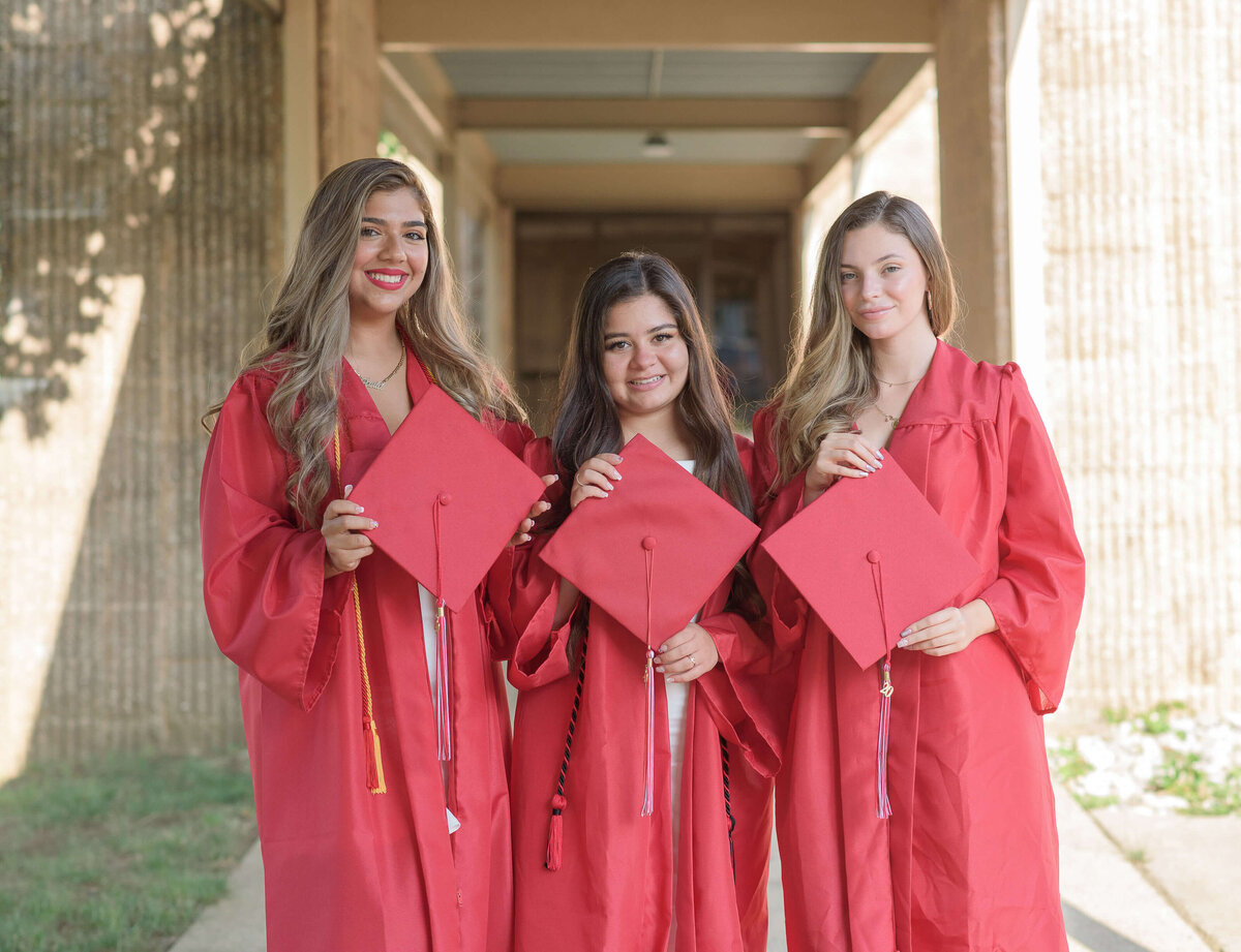 group of high school senior posing on their graduation day wearing red gowns in atlanta georgia