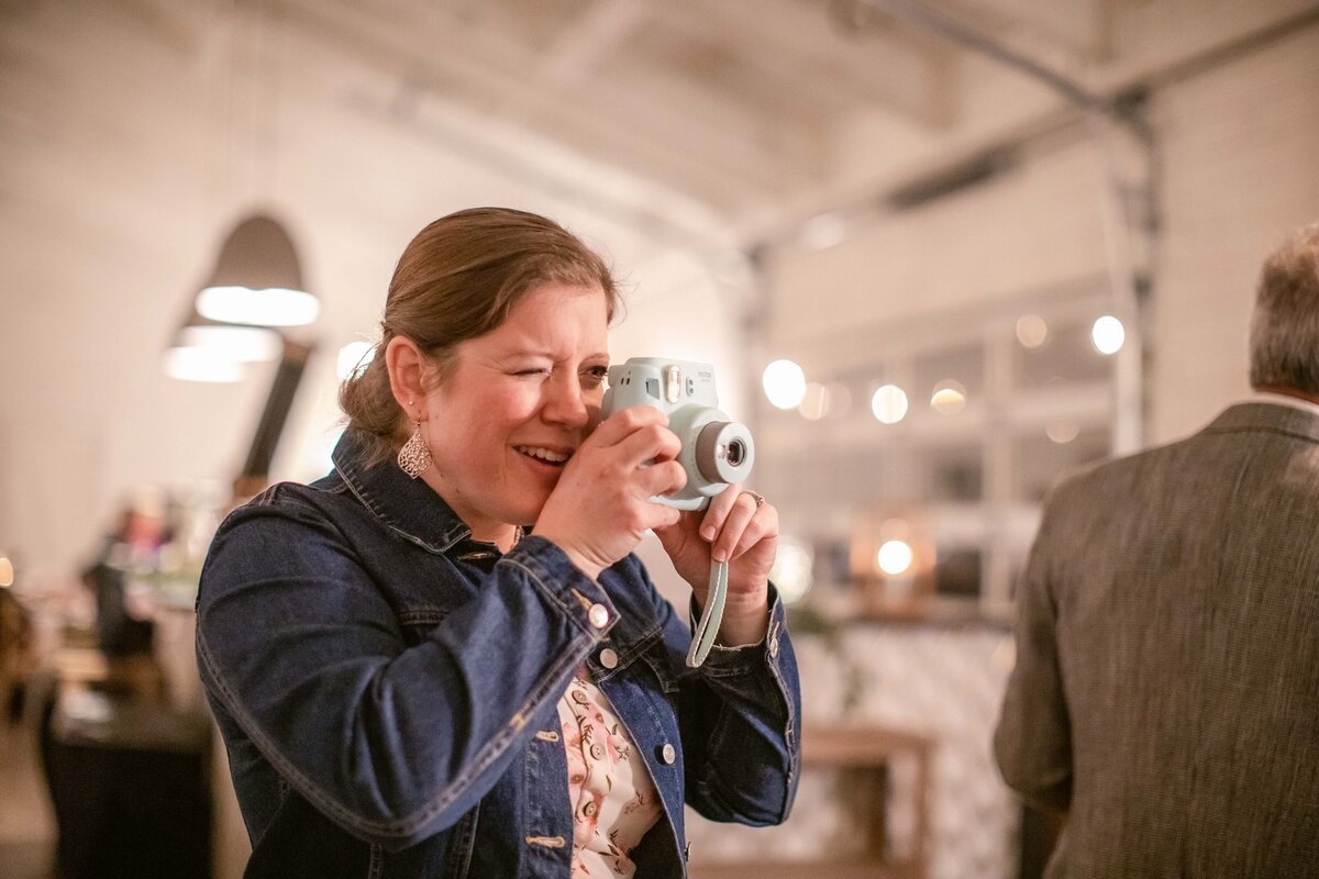 guest uses instant camera at wedding reception