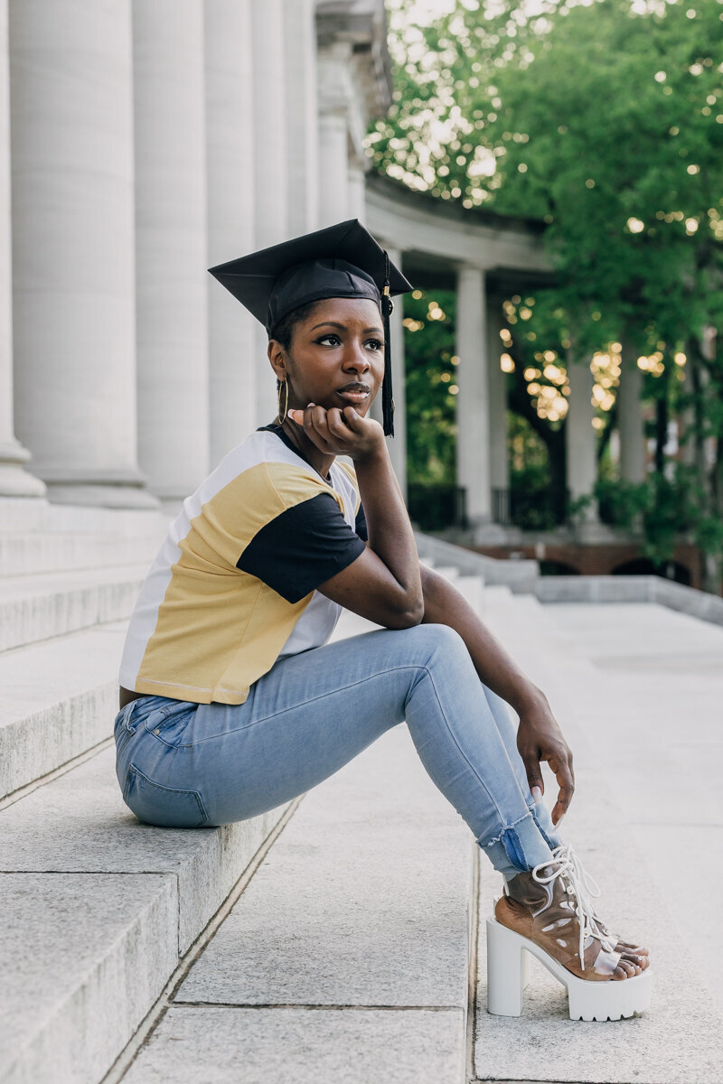 Vanderbilt University graduate sitting on steps, gazing off into the distance