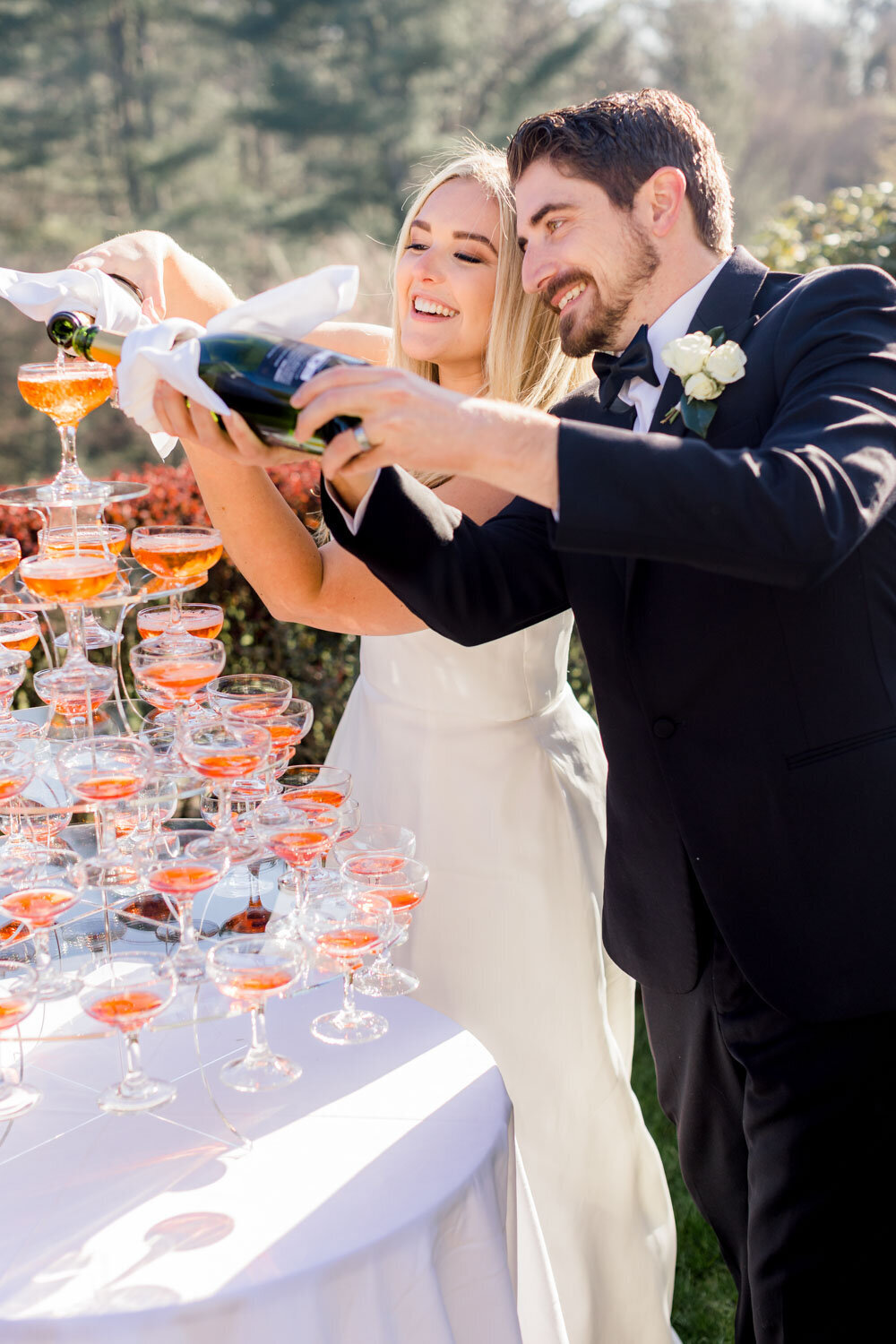 Bride and groom pouring champagne to their champagne tower