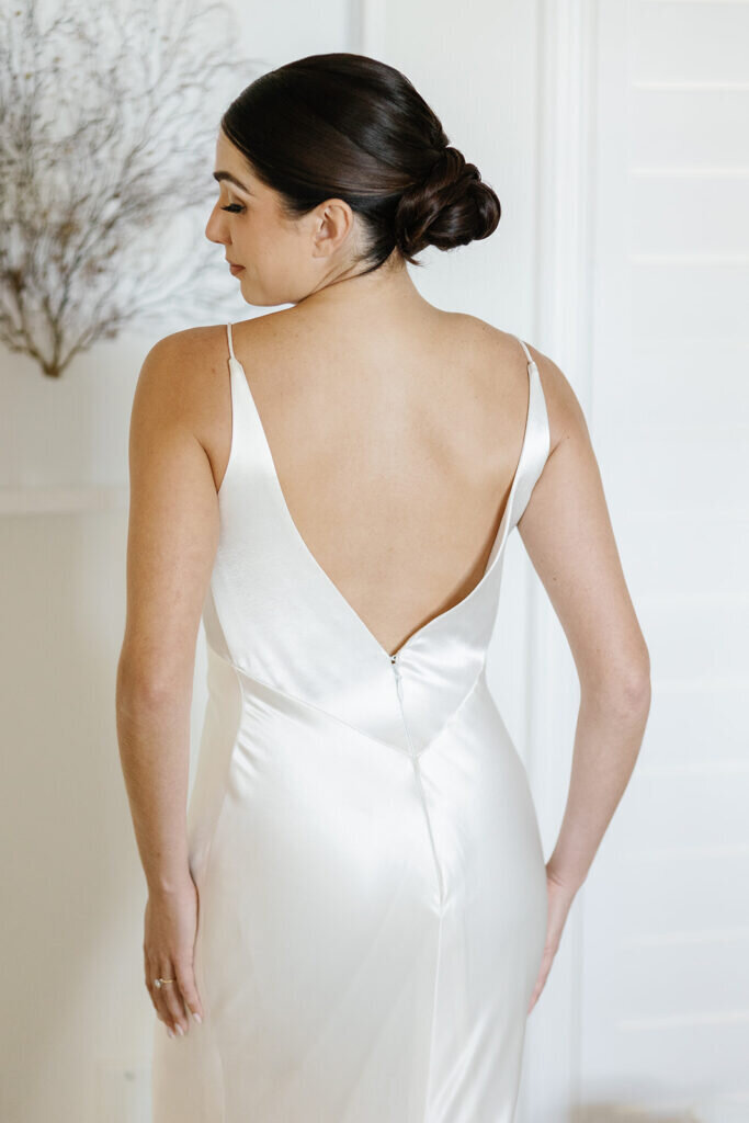 A stunning back view of the bride in her elegant open-back satin wedding gown, highlighting its sleek design. Captured by Claudia Amalia Photography, a Florida Keys wedding photographer specializing in destination wedding photography.