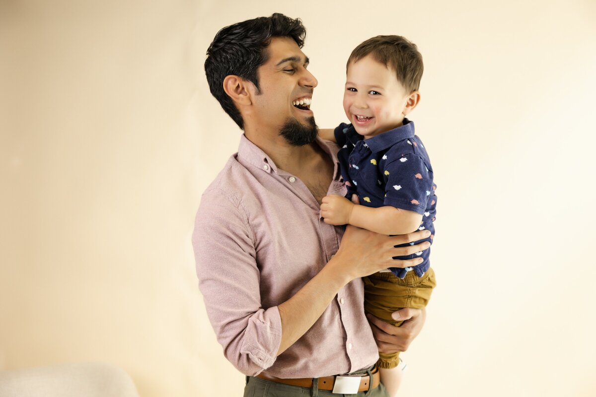 dan laughing with son in a sacramento family photo studio